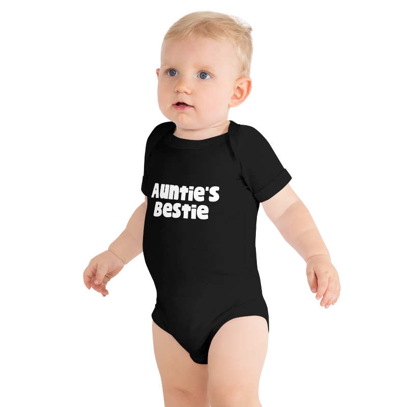 Baby wearing a black onesie with 'Auntie's Bestie' text, on plain background, by Less Hustle, More Joy.