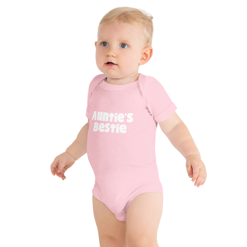 Baby wearing a pink onesie with white 'Auntie's Bestie' text, on plain background, by Less Hustle, More Joy.