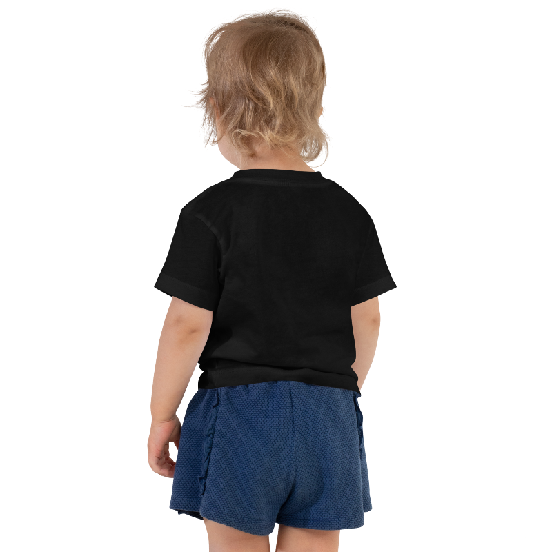 A photo showing the back of a child wearing a black t-shirt with white text that reads 'Auntie's Bestie'. By Less Hustle, More Joy.