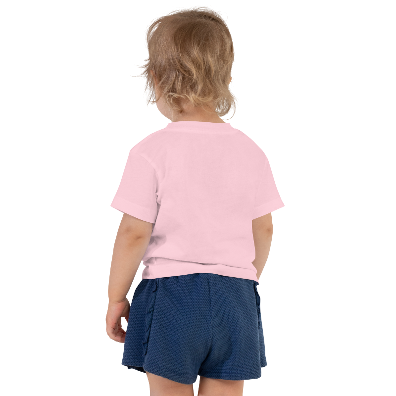 An image of the back of a child wearing a pink t-shirt with white text on the front that reads 'Auntie's Bestie. By Less Hustle, More Joy.