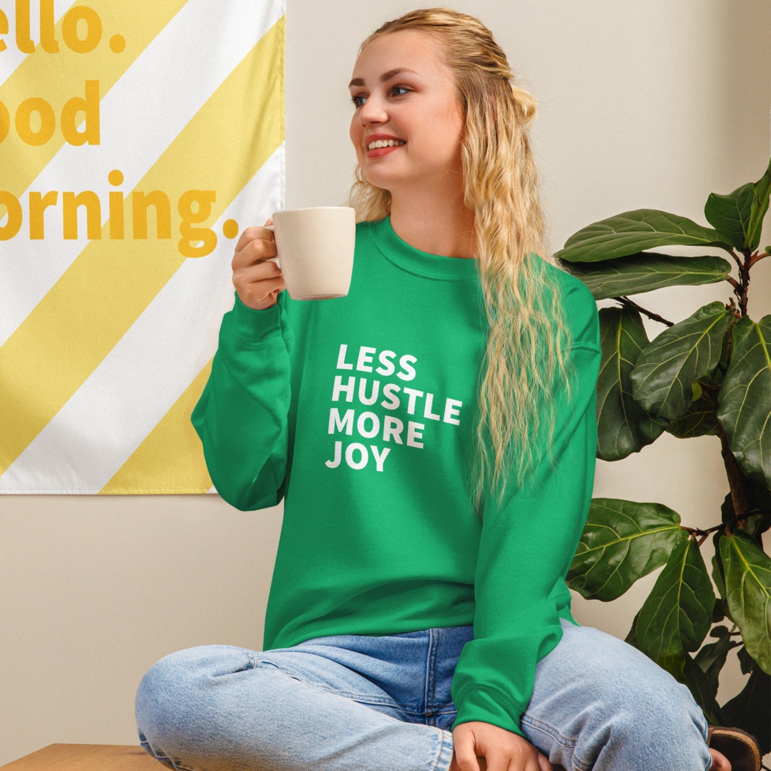 white woman wearing Less Hustle, More Joy sweatshirt in Irish Green