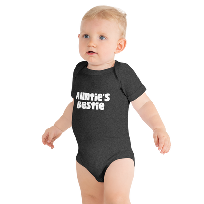 Baby wearing a dark, grey heather onesie with 'Auntie's Bestie' text, on plain background by Less Hustle, More Joy.