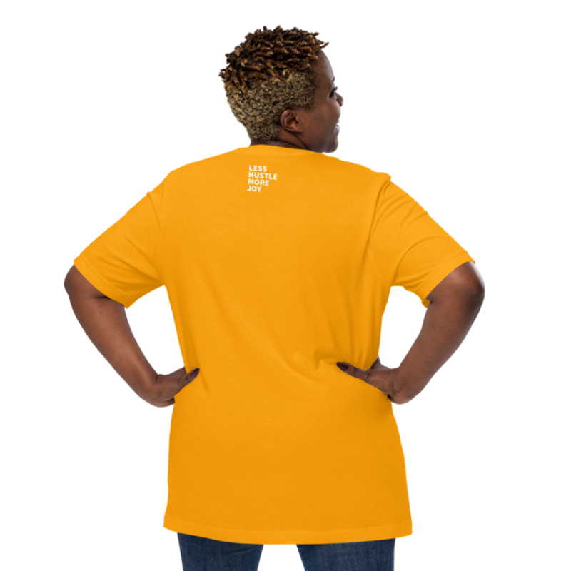 A person shown from the back wearing a gold crew neck t-shirt by Less Hustle, More Joy with the phrase 'In My Sunshine Era' printed in white text on the front.