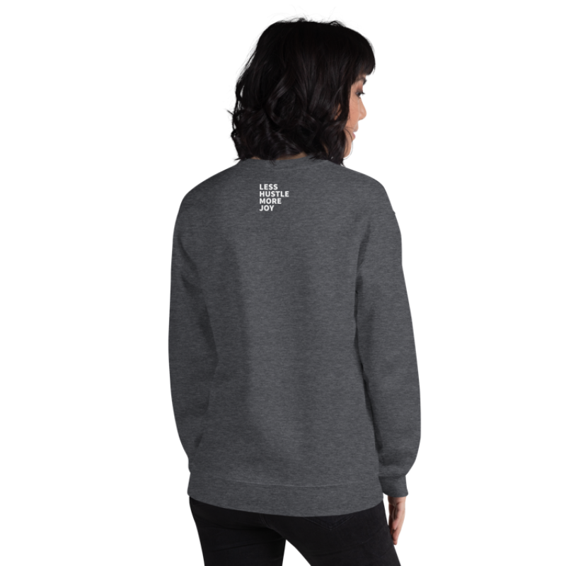 A person shown from the back wearing a dark grey heather sweatshirt from Less Hustle, More Joy with the text 'PLANT LOVER' on the front in white and Less Hustle More Joy text in white on the back.