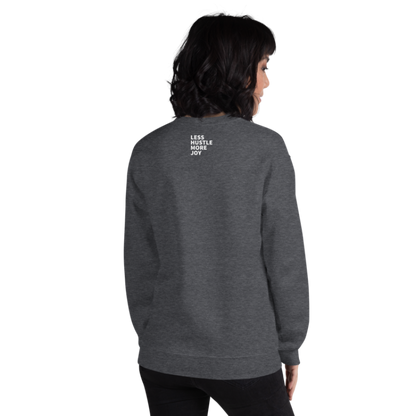 A person shown from the back wearing a dark grey heather sweatshirt from Less Hustle, More Joy with the text 'PLANT LOVER' on the front in white and Less Hustle More Joy text in white on the back.