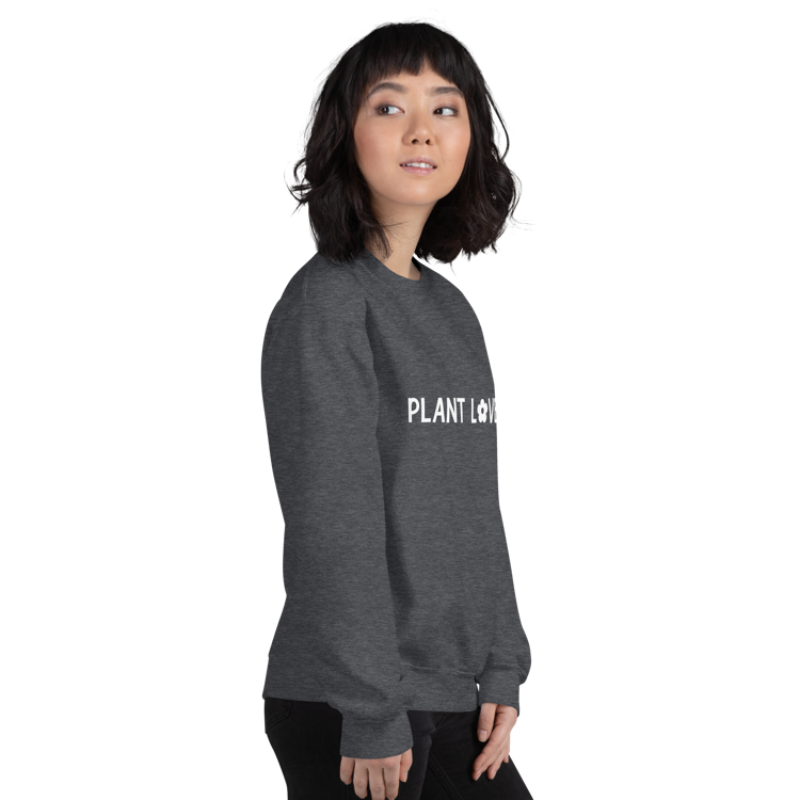 A person facing the right wearing a dark grey heather sweatshirt from Less Hustle, More Joy with the words 'PLANT LOVER' printed on the front in white text.