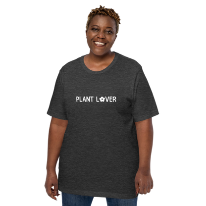 A person wearing a dark grey heather t-shirt by Less Hustle, More Joy, with the words 'PLANT LOVER' printed on the front in white text.
