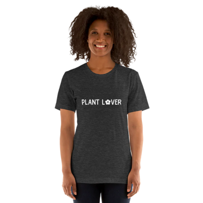A person wearing a dark grey heather t-shirt by Less Hustle, More Joy, with the words 'PLANT LOVER' printed on the front in white text.