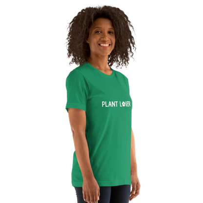 A person standing side-on wearing a kelly green heather t-shirt, by Less Hustle, More Joy, with the words 'PLANT LOVER' printed on the front in white text.