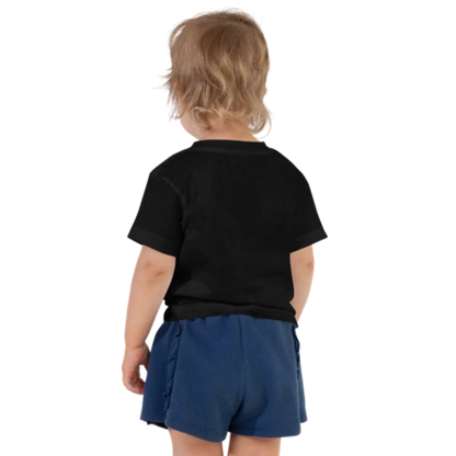 Back view of a black, short-sleeved toddler tee by Less Hustle, More Joy. The front features the word 'Strong' printed in punk rock pink text.