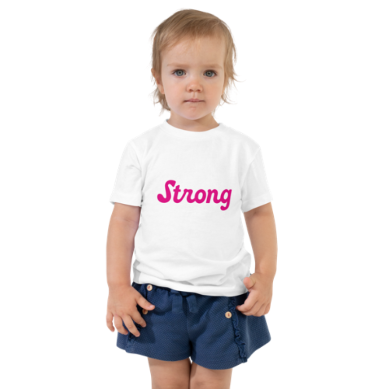 Front view of a white, short-sleeved toddler tee by Less Hustle, More Joy. The front features the word 'Strong' printed in punk rock pink text.